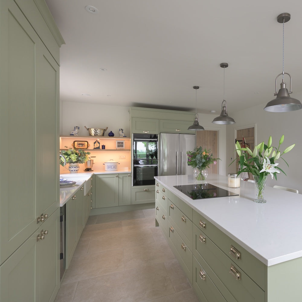 Green traditional kitchen with green cabinets and white countertops